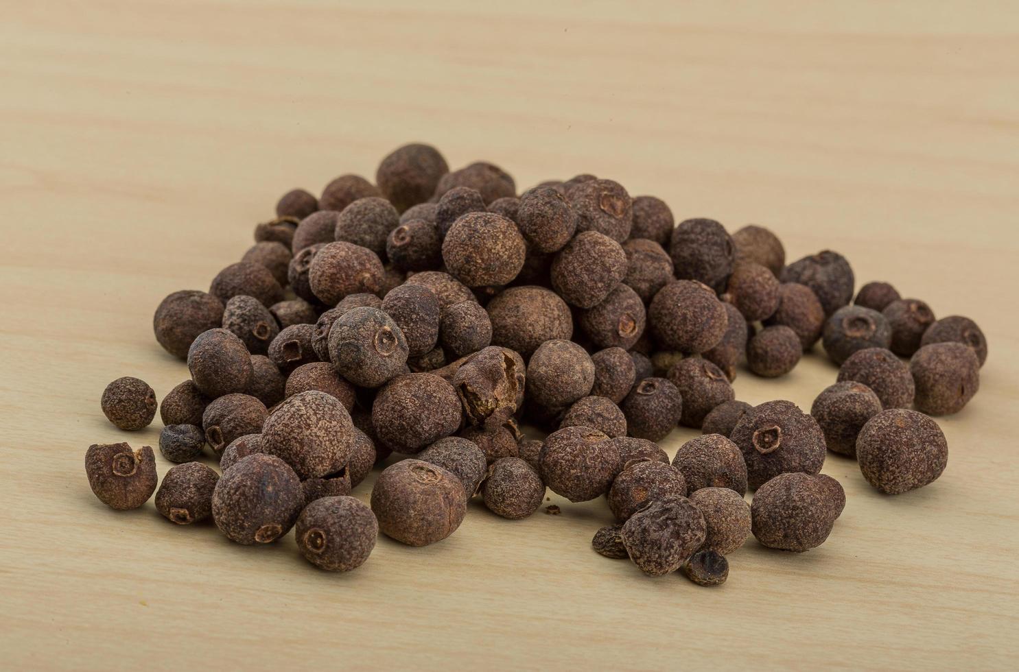 Black pepper on wooden background photo