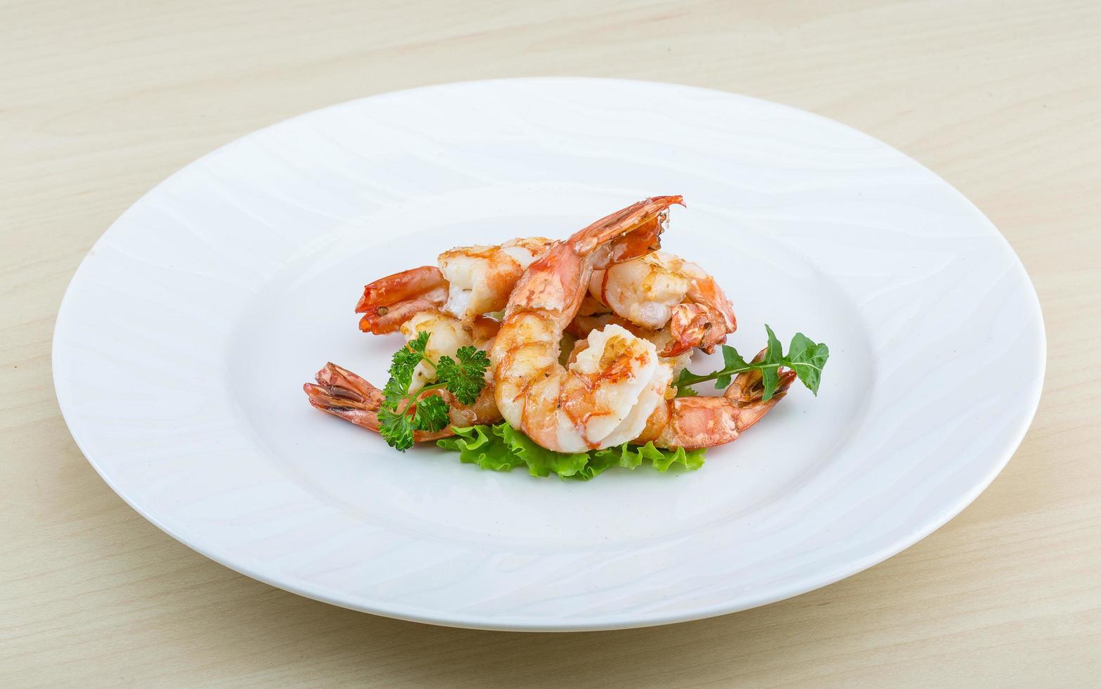 Tiger shrimps on the plate and wooden background photo