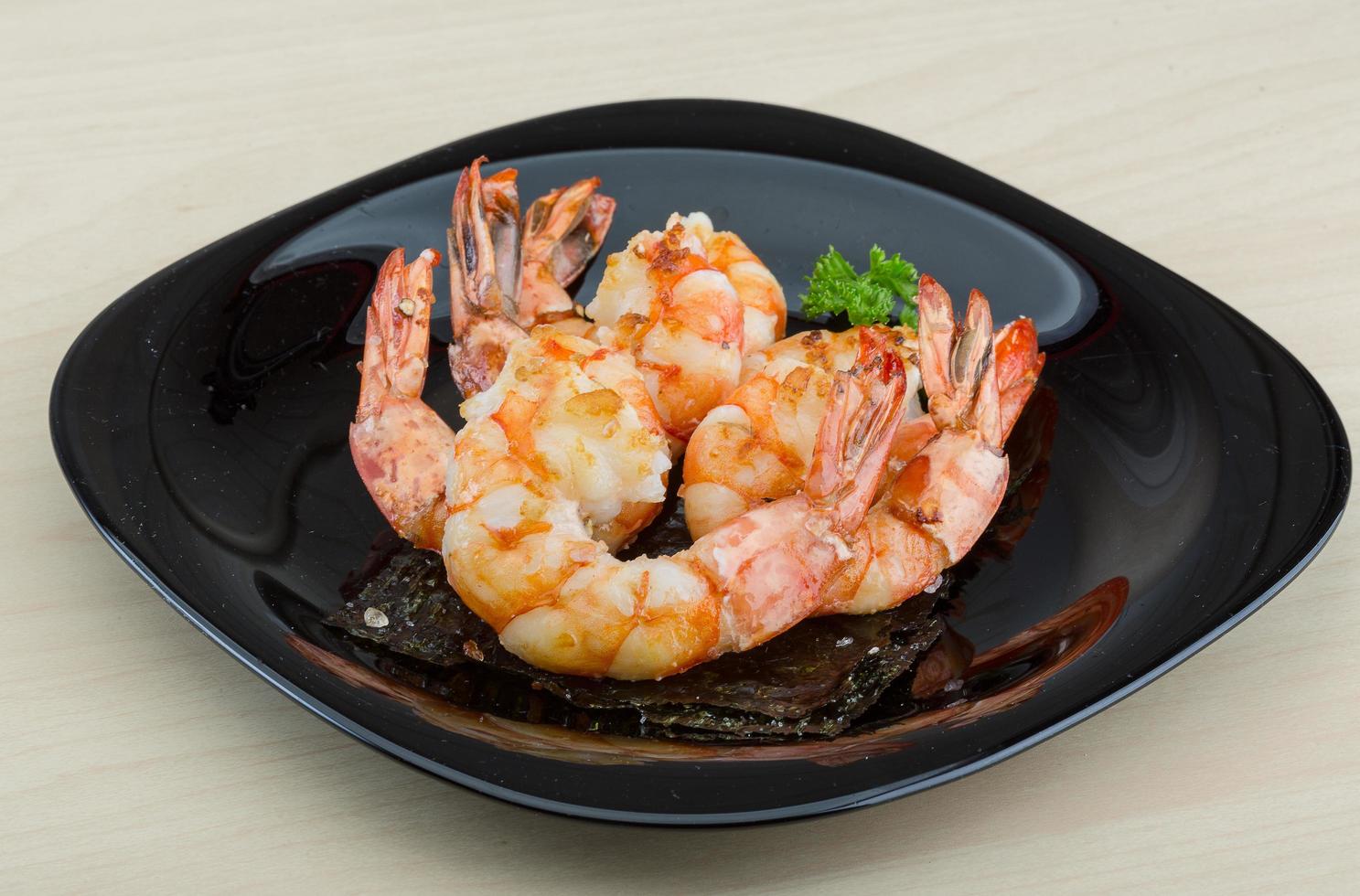 Tiger shrimps on the plate and wooden background photo