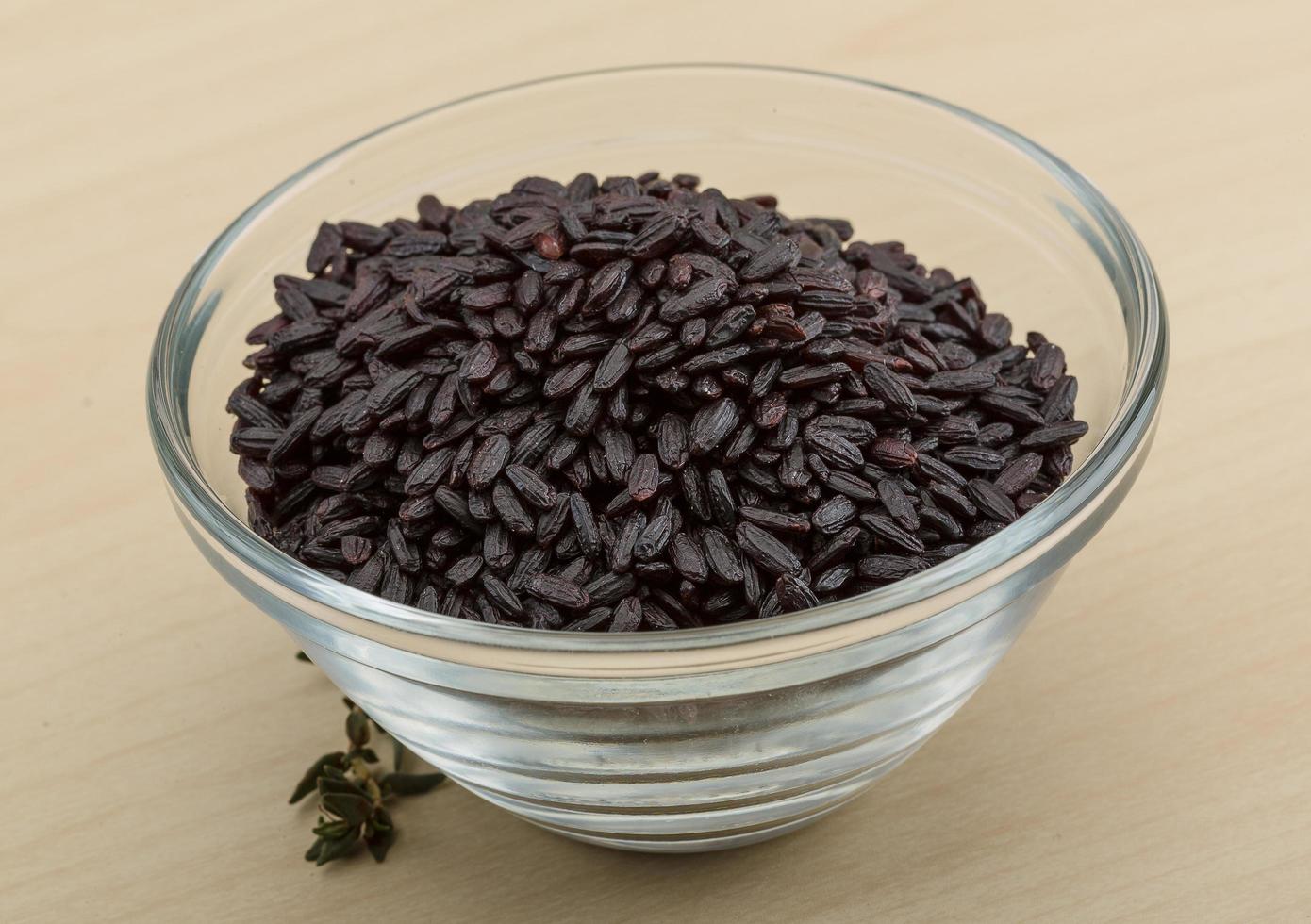 Black rice in a bowl on wooden background photo