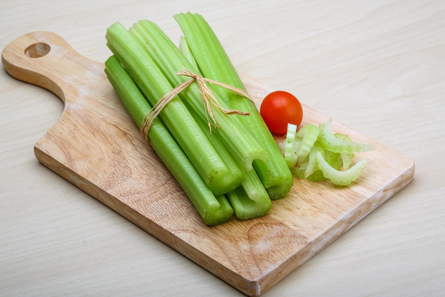 Celery on wooden board and wooden background photo