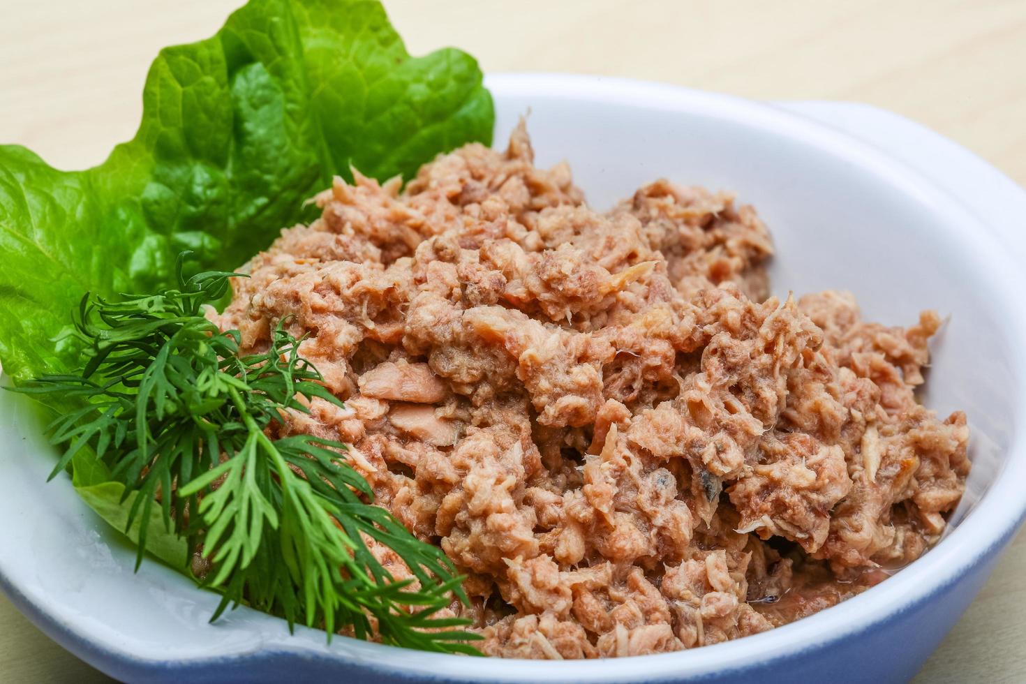 Cannded runa in a bowl on wooden background photo