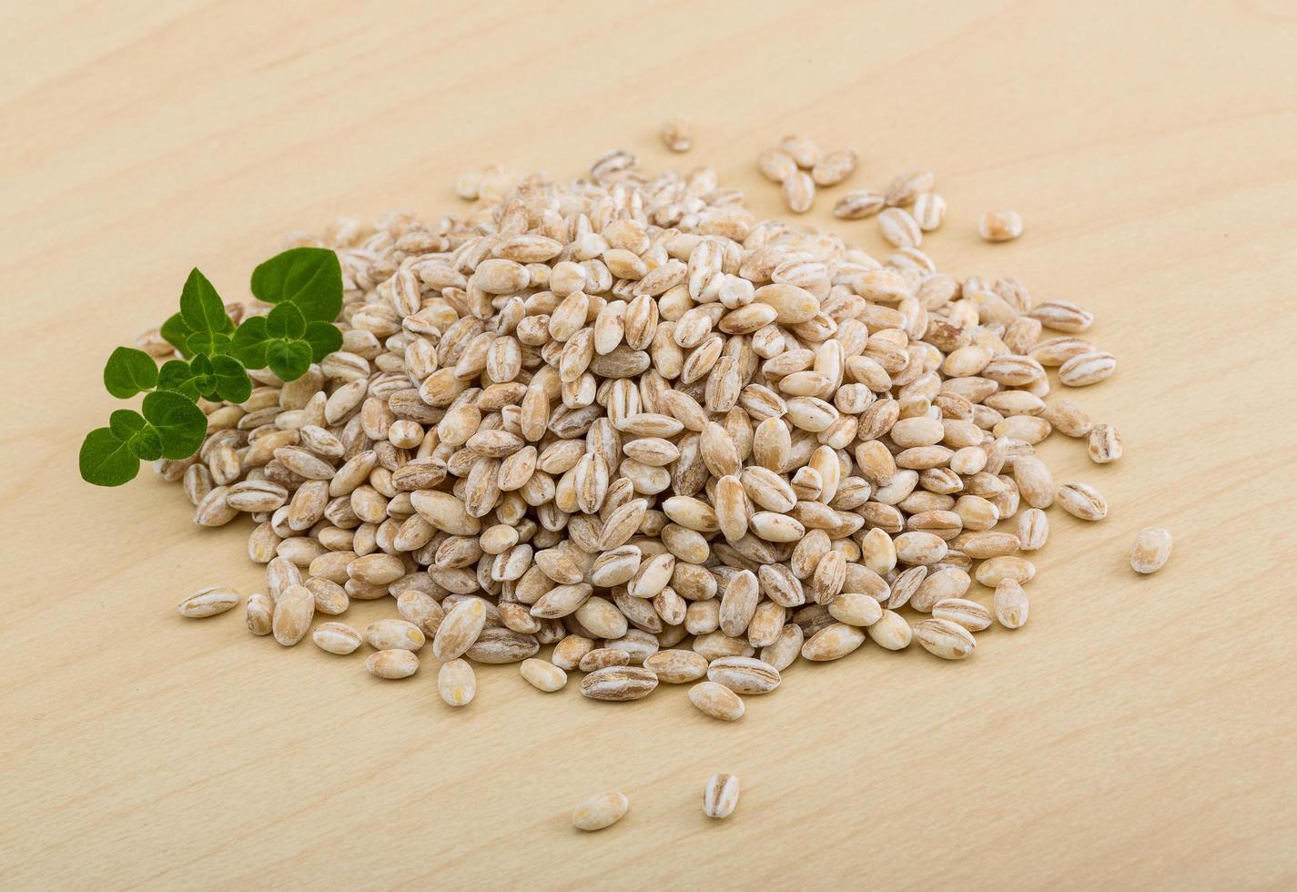 Pearl barley on wooden background photo