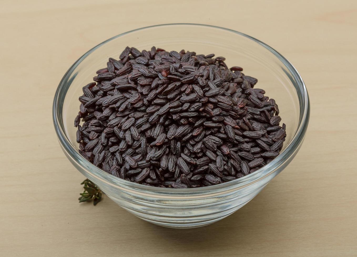 Black rice in a bowl on wooden background photo