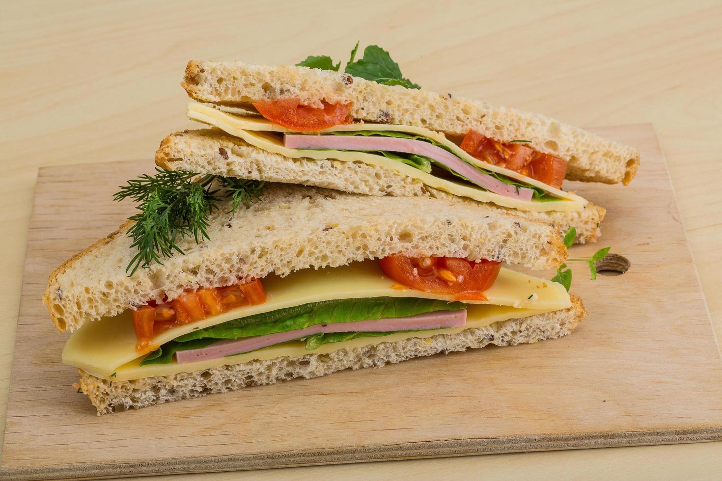 Club sandwich on wooden board and wooden background photo