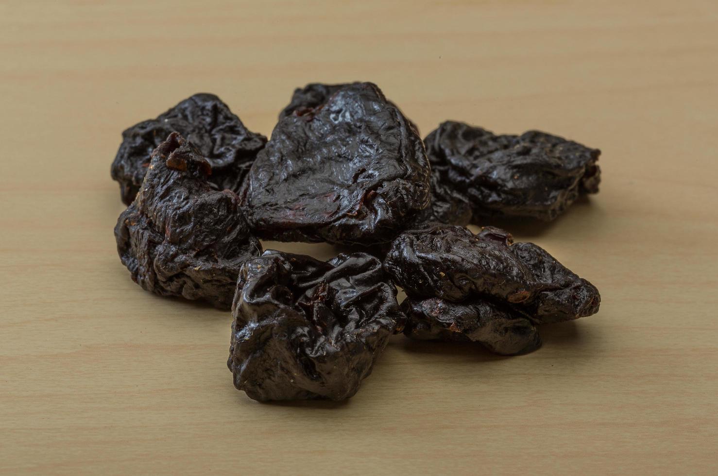 Dry plum on wooden background photo