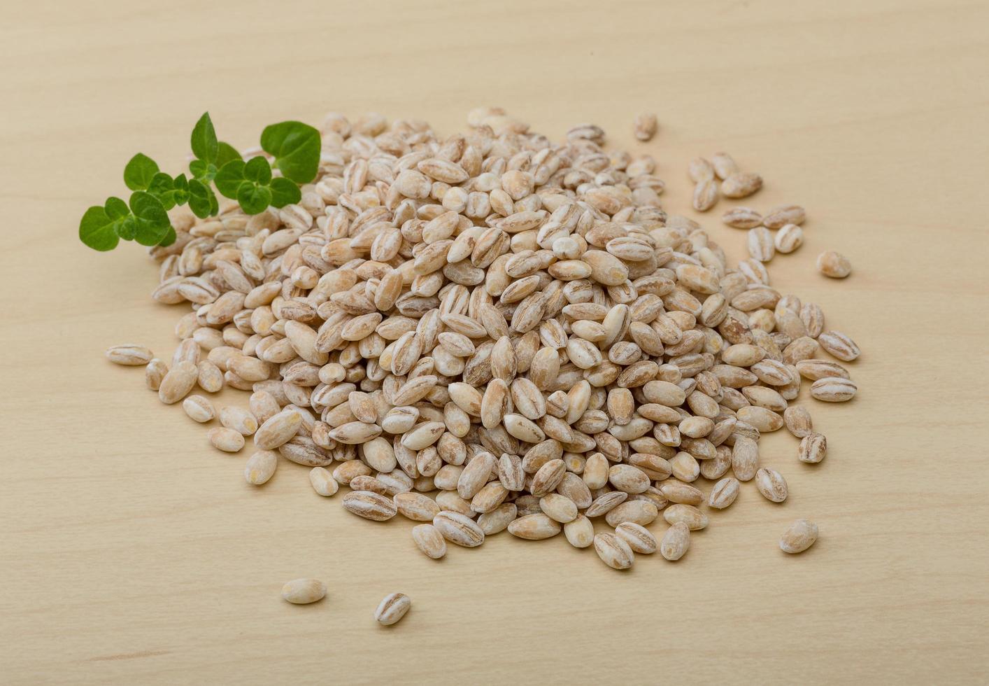 Pearl barley on wooden background photo