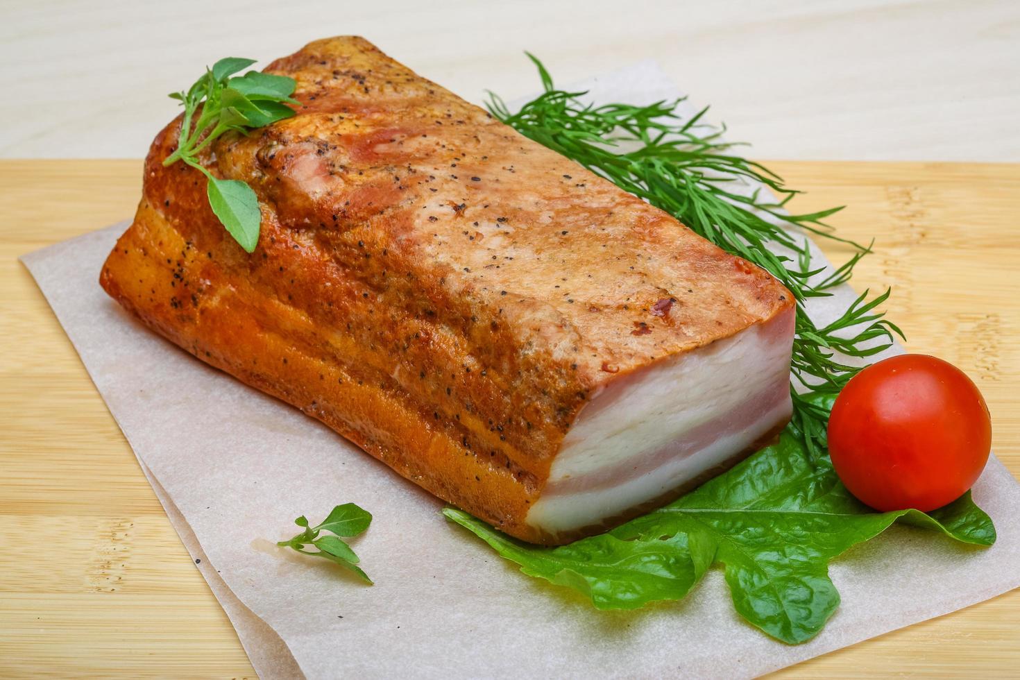 Raw bacon on wooden board and wooden background photo