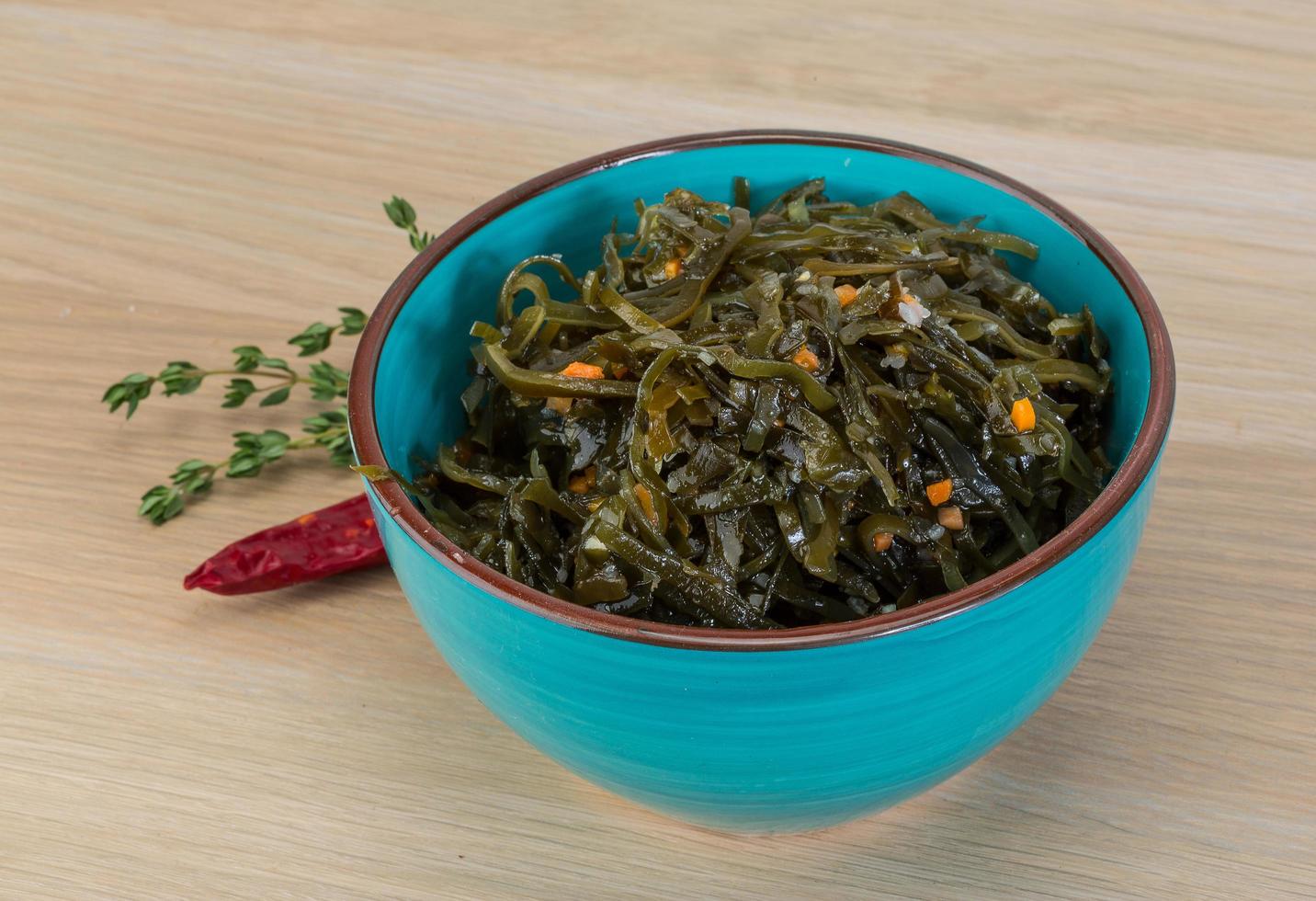 Laminaria salad in a bowl on wooden background photo