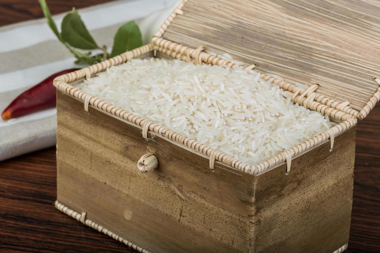 Basmati rice in a basket on wooden background photo