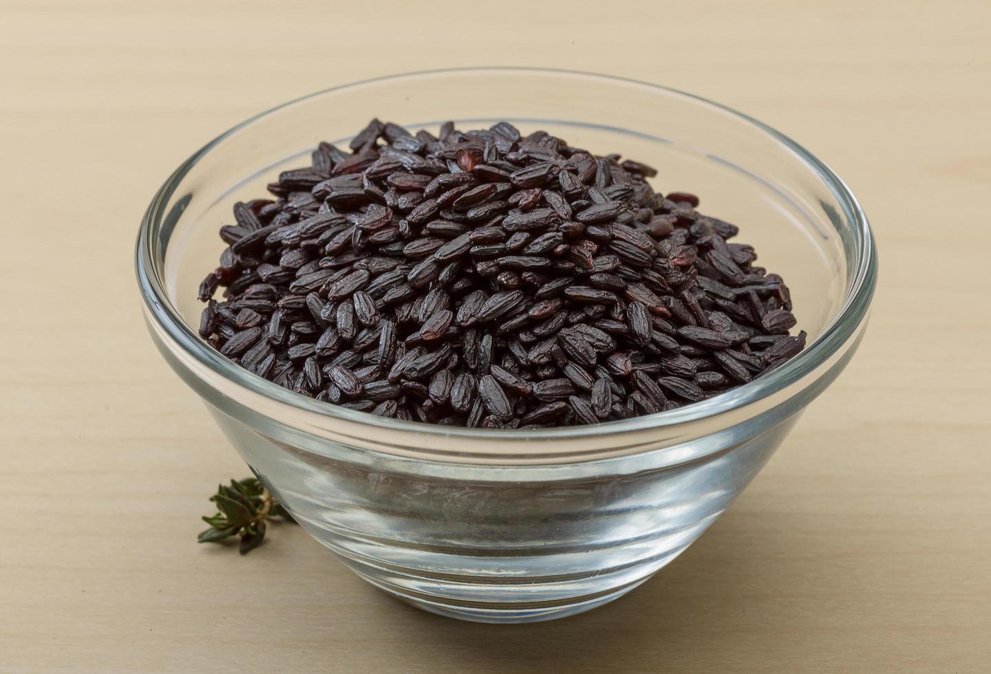 Black rice in a bowl on wooden background photo