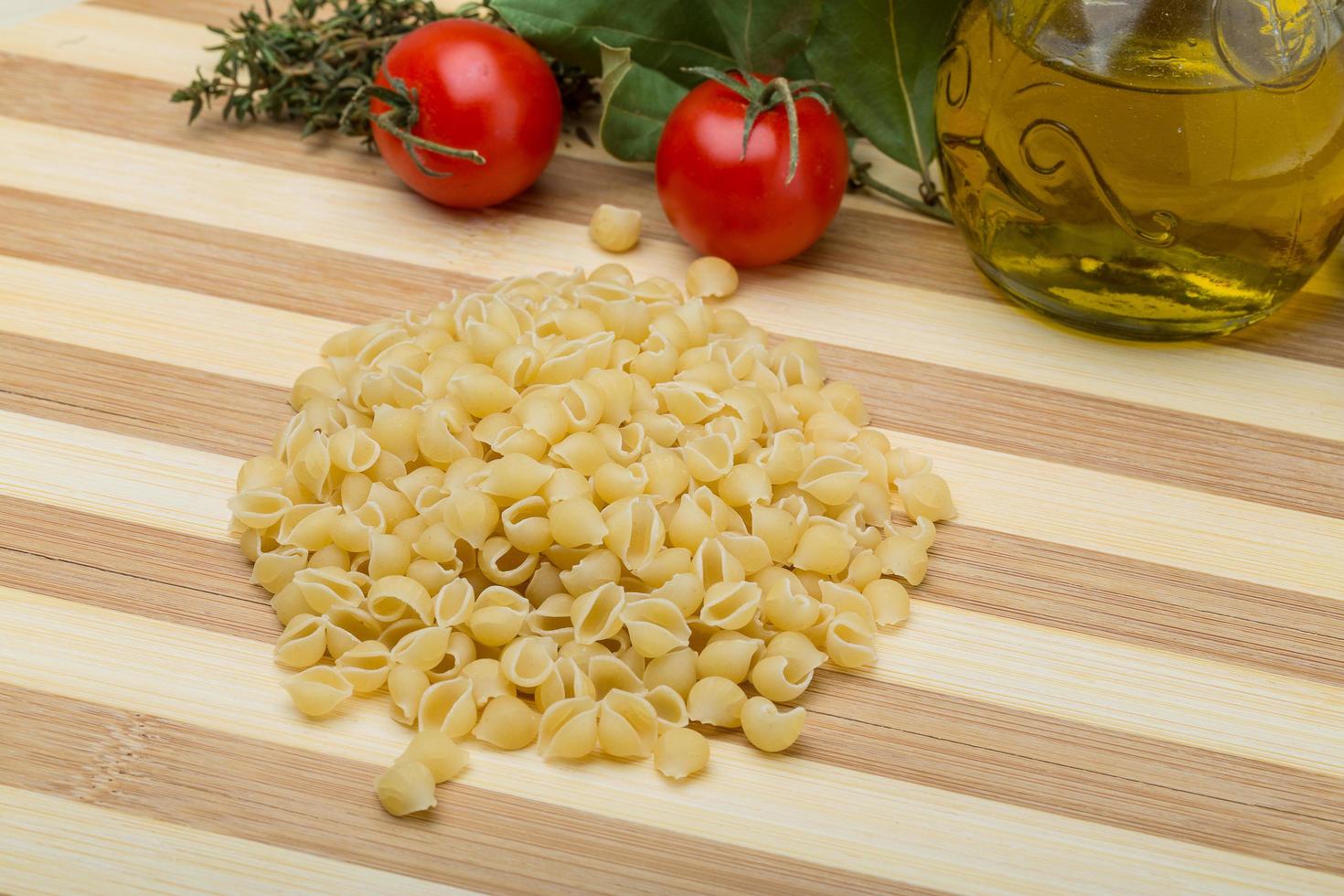 pasta de concha sobre tablero de madera y fondo de madera foto