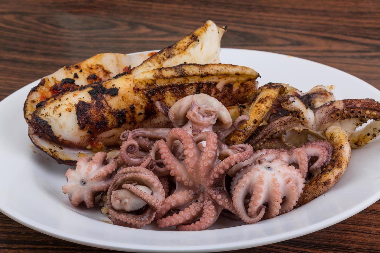 pulpo hervido en el plato y fondo de madera foto