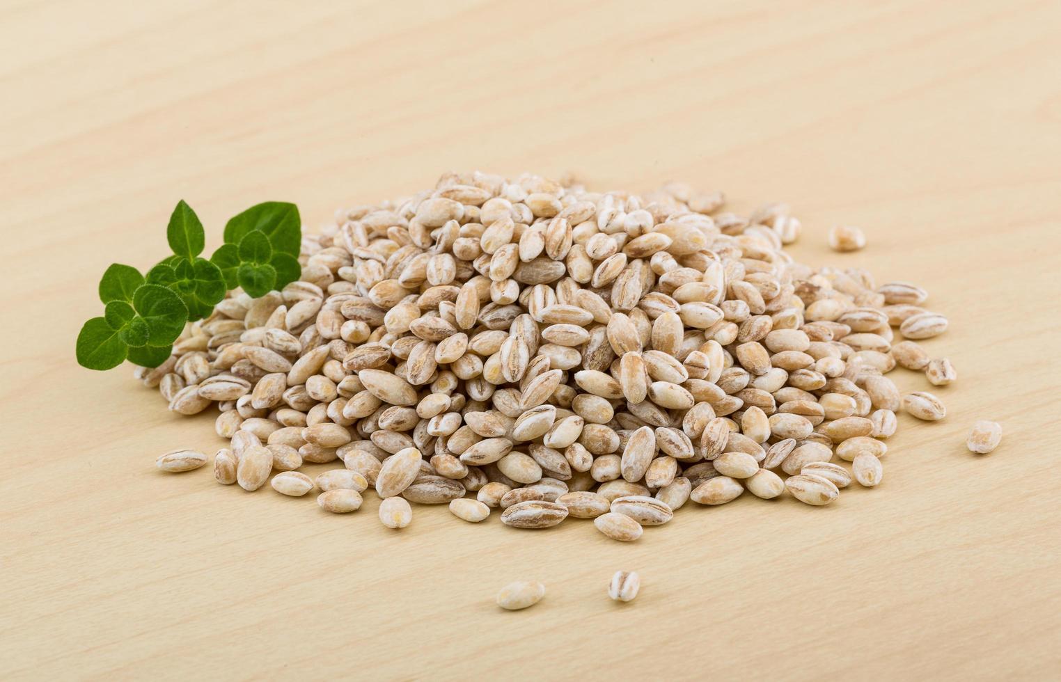 Pearl barley on wooden background photo