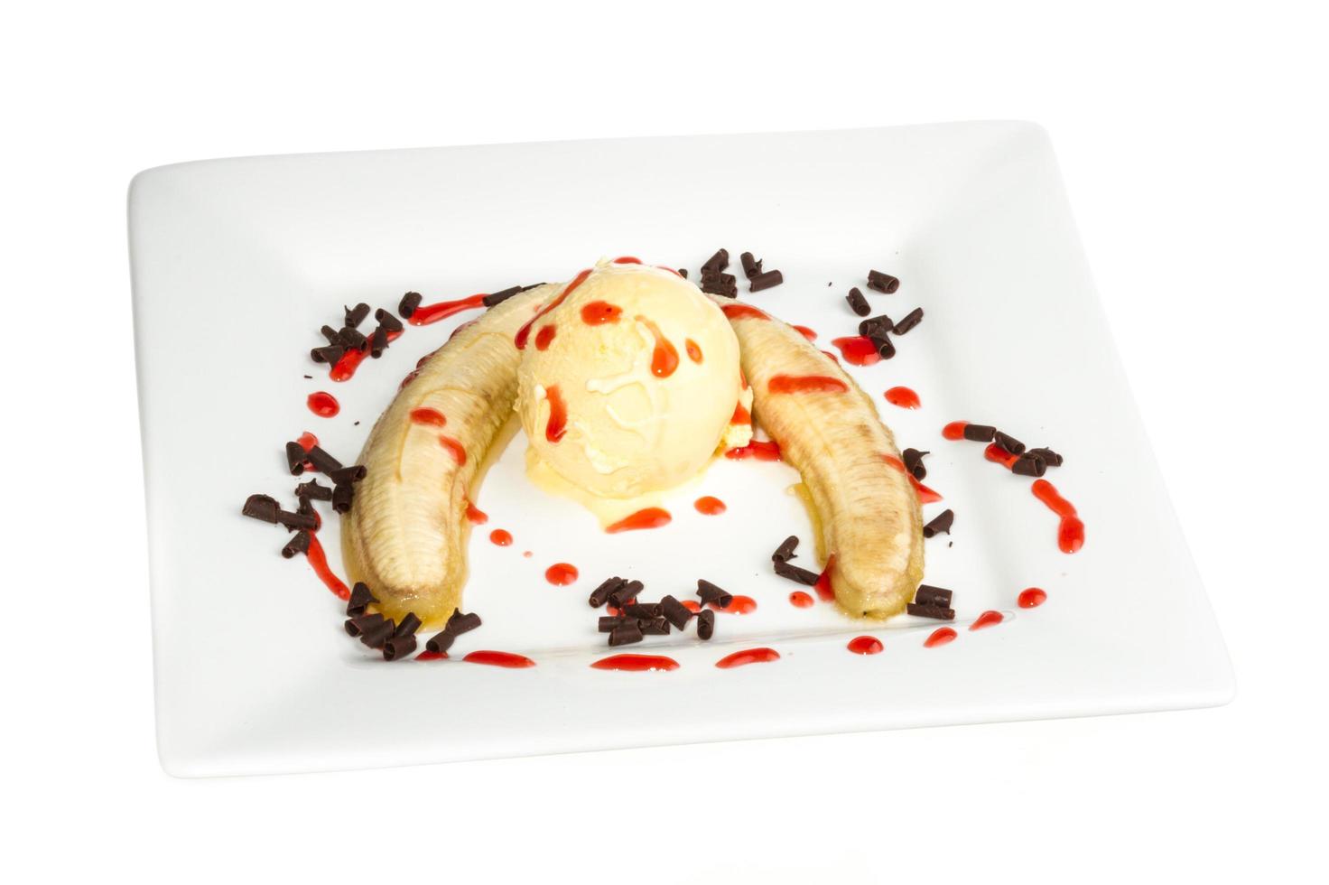 Bake banana with vanilla ice cream and caramel syrup isolated on white with clipping path photo