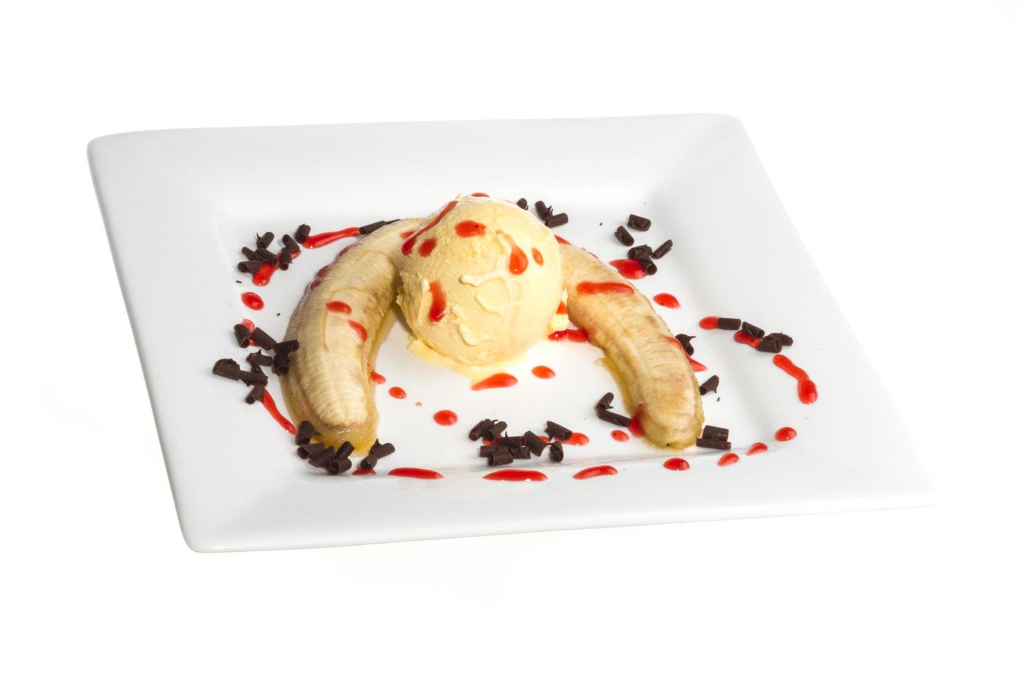 Bake banana with vanilla ice cream and caramel syrup isolated on white with clipping path photo