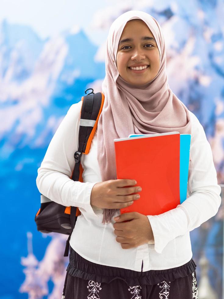 a portrait of a happy Middle Eastern university student in front of a snowy mountain in the background photo