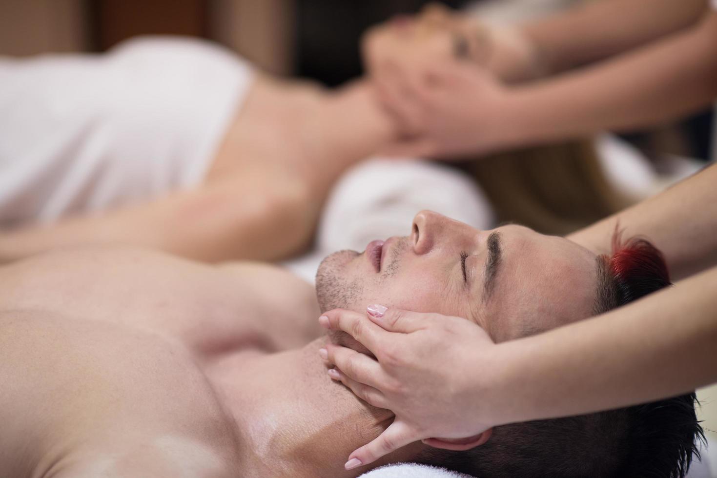 pareja disfrutando de un masaje de cabeza en el spa foto