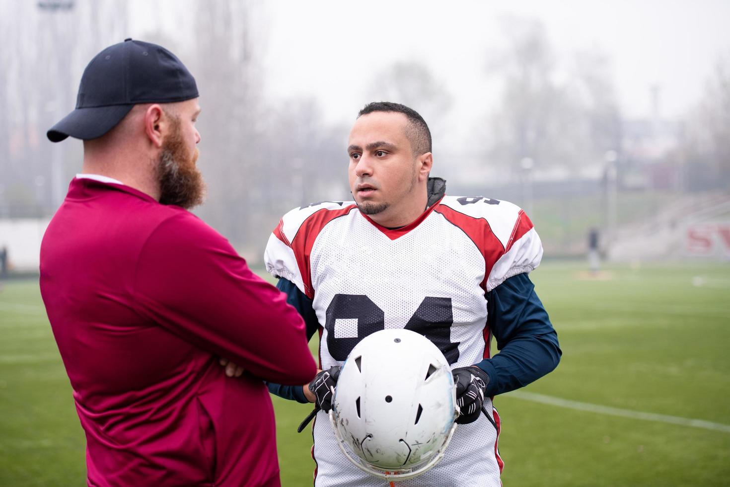 american football player discussing strategy with coach photo