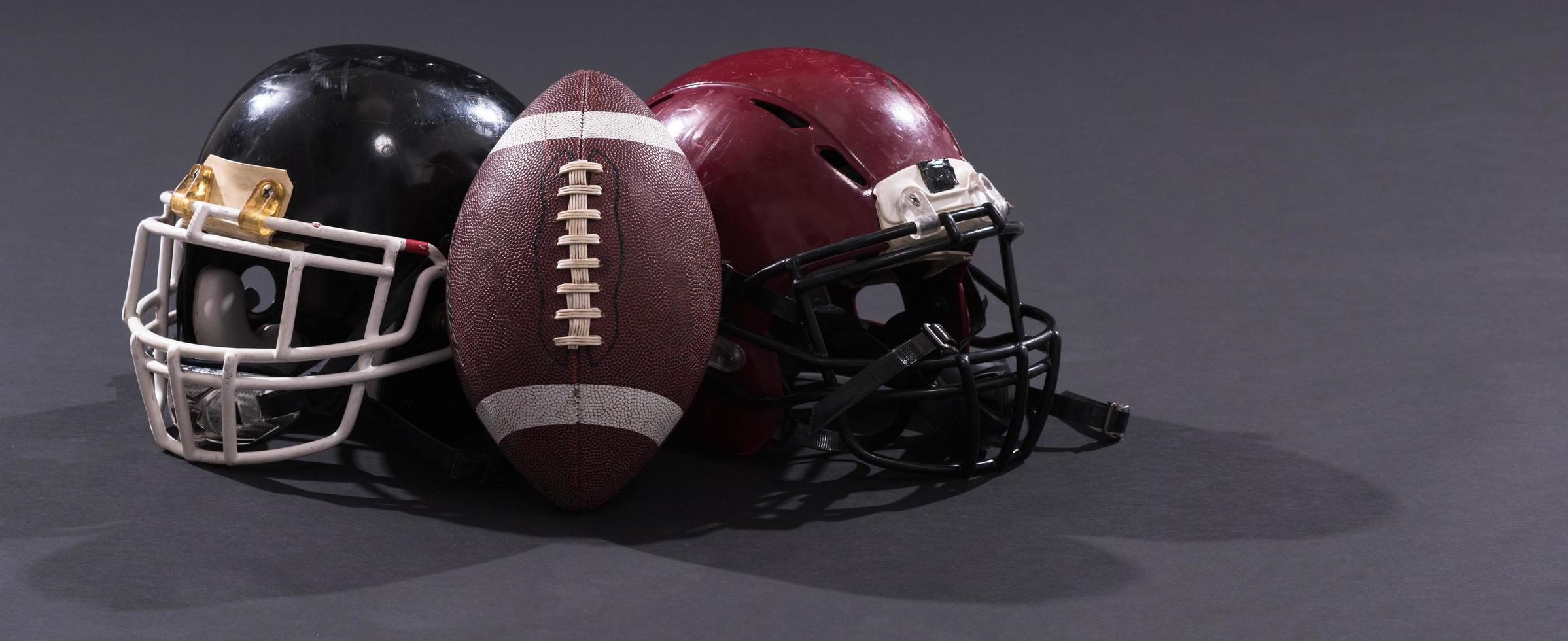american football and helmets isolated on gray photo