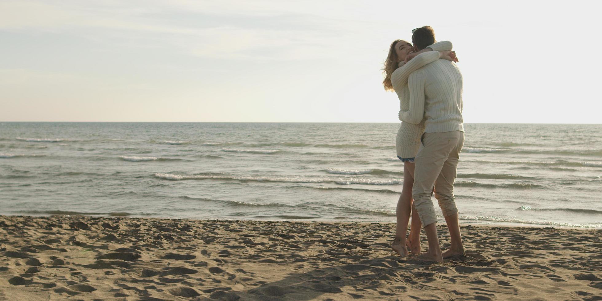 Loving young couple on a beach at autumn on sunny day photo
