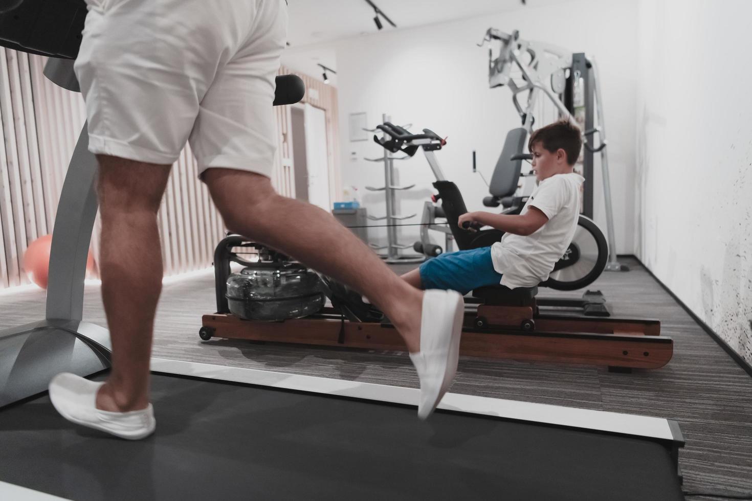 padre e hijo entrenan juntos en el gimnasio de casa. el concepto de vida sana. enfoque selectivo foto