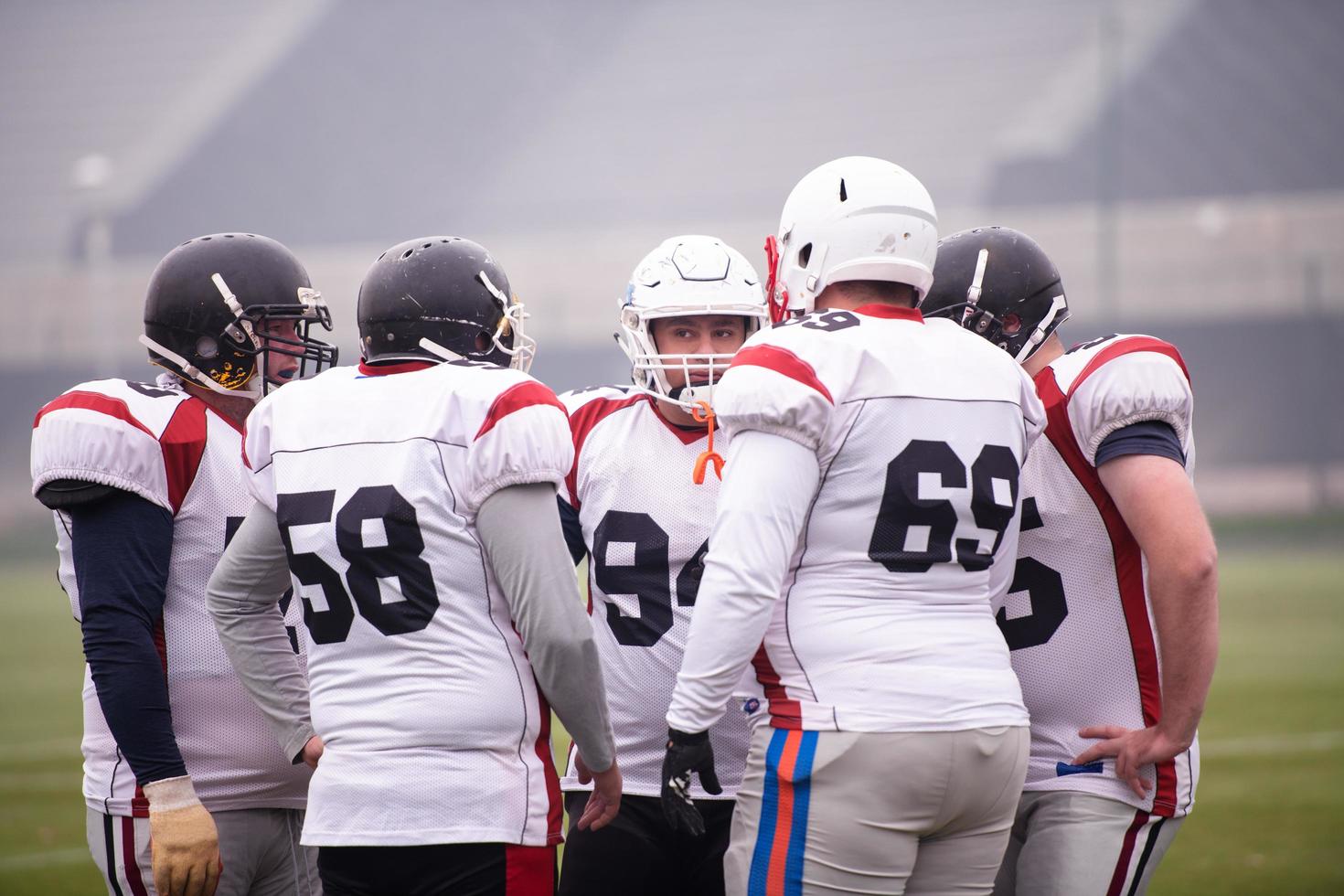 american football players discussing strategy photo