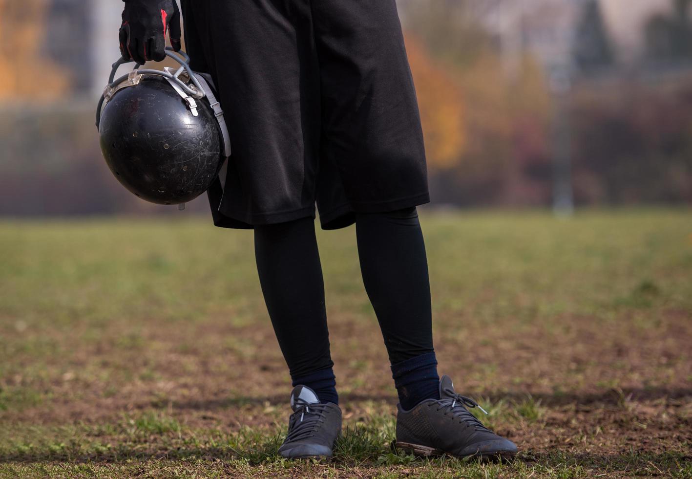 American football player holding helmet photo