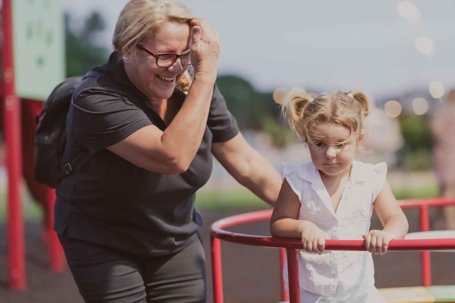 An older grandmother is playing with her grandson in the park at sunset. Selective focus photo