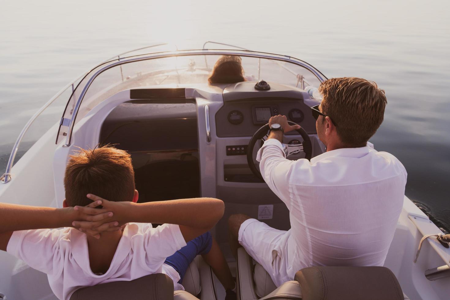 A senior couple in casual outfits with their son enjoy while riding a boat at sea at sunset. The concept of a happy family. Selective focus photo