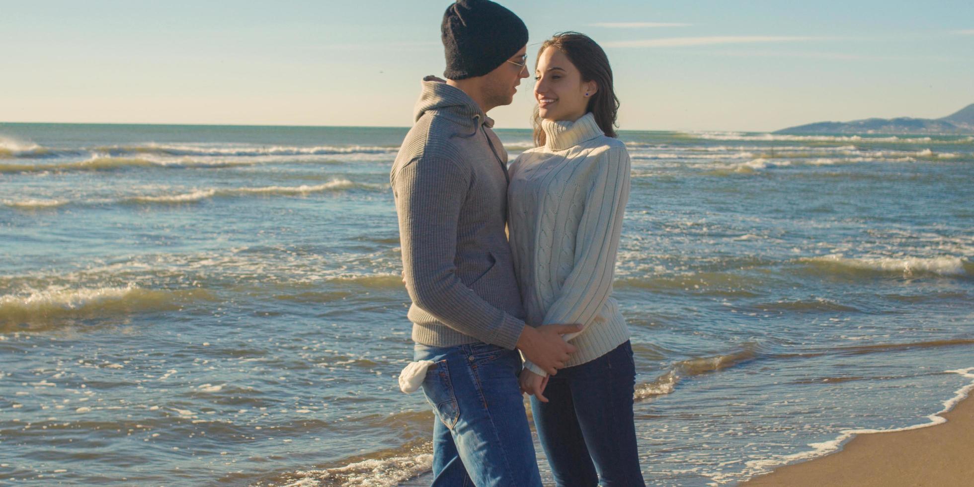 Couple having fun on beautiful autumn day at beach photo