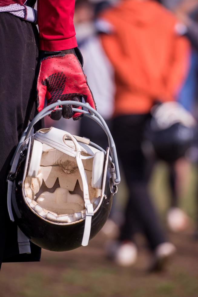 American football player holding helmet photo