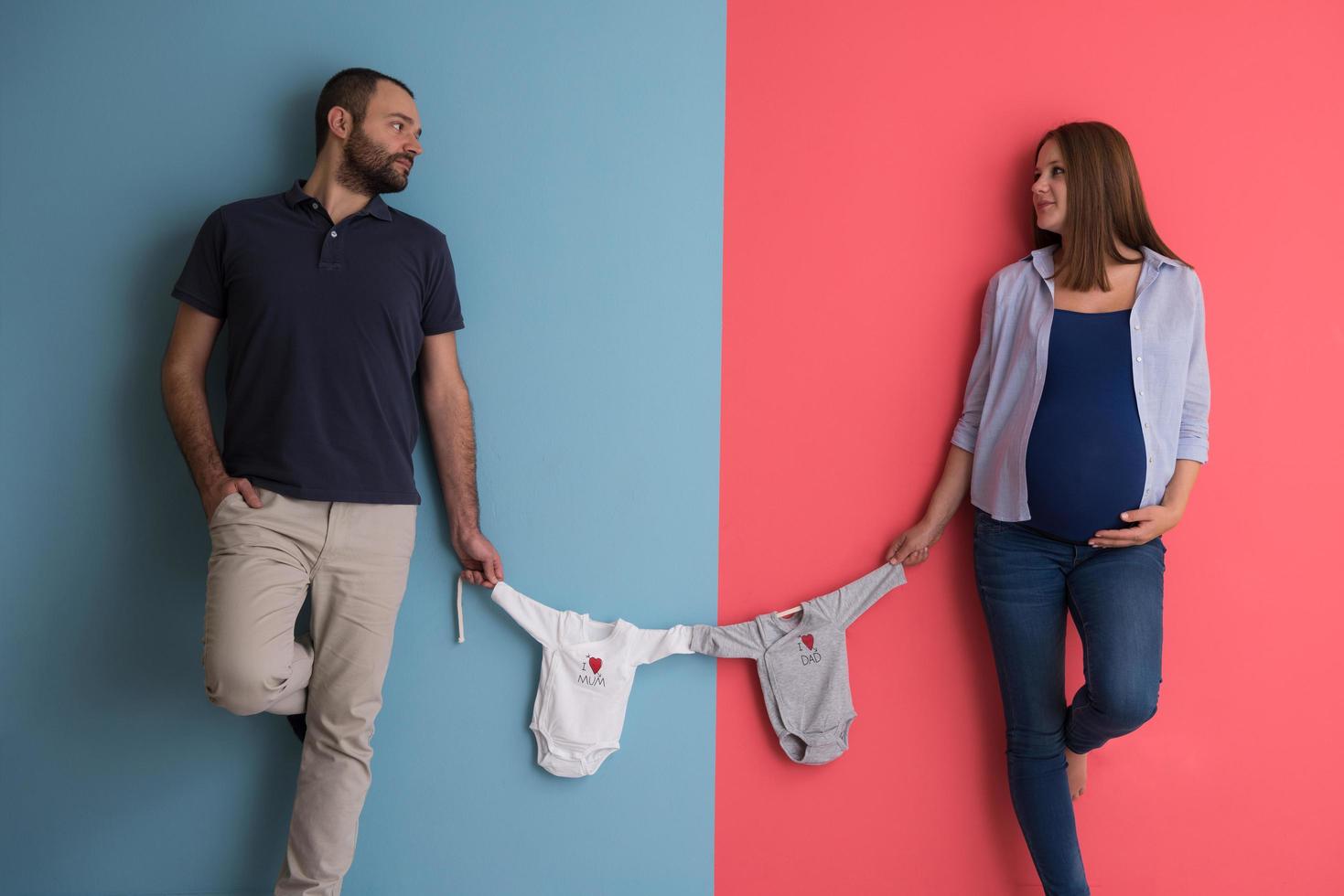 young couple holding baby bodysuits photo