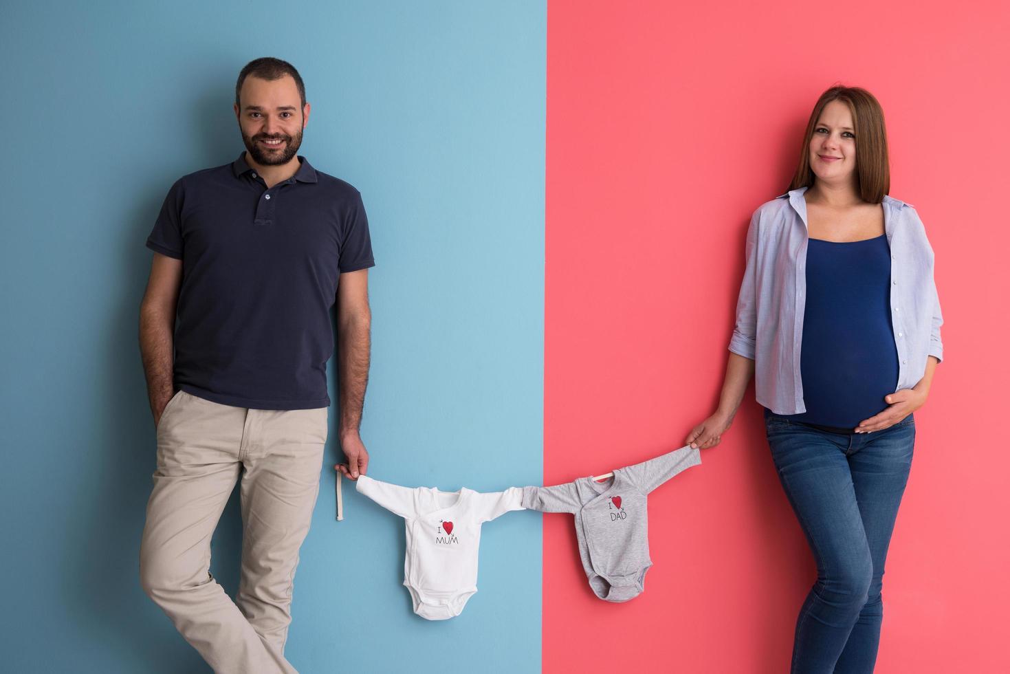 young couple holding baby bodysuits photo