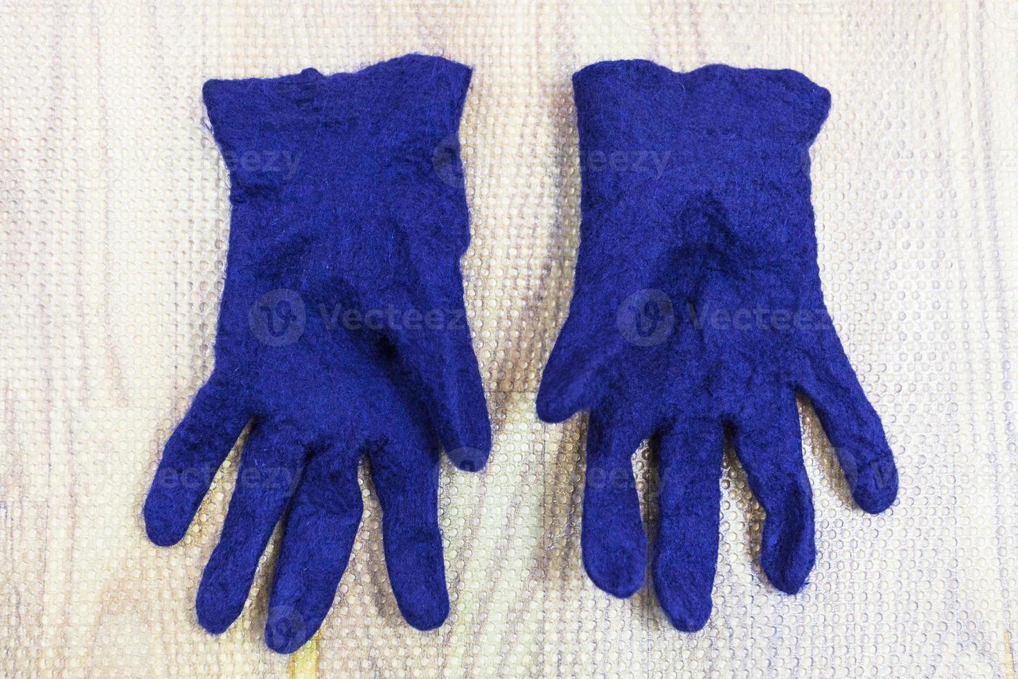 finished wet felted gloves on mat photo