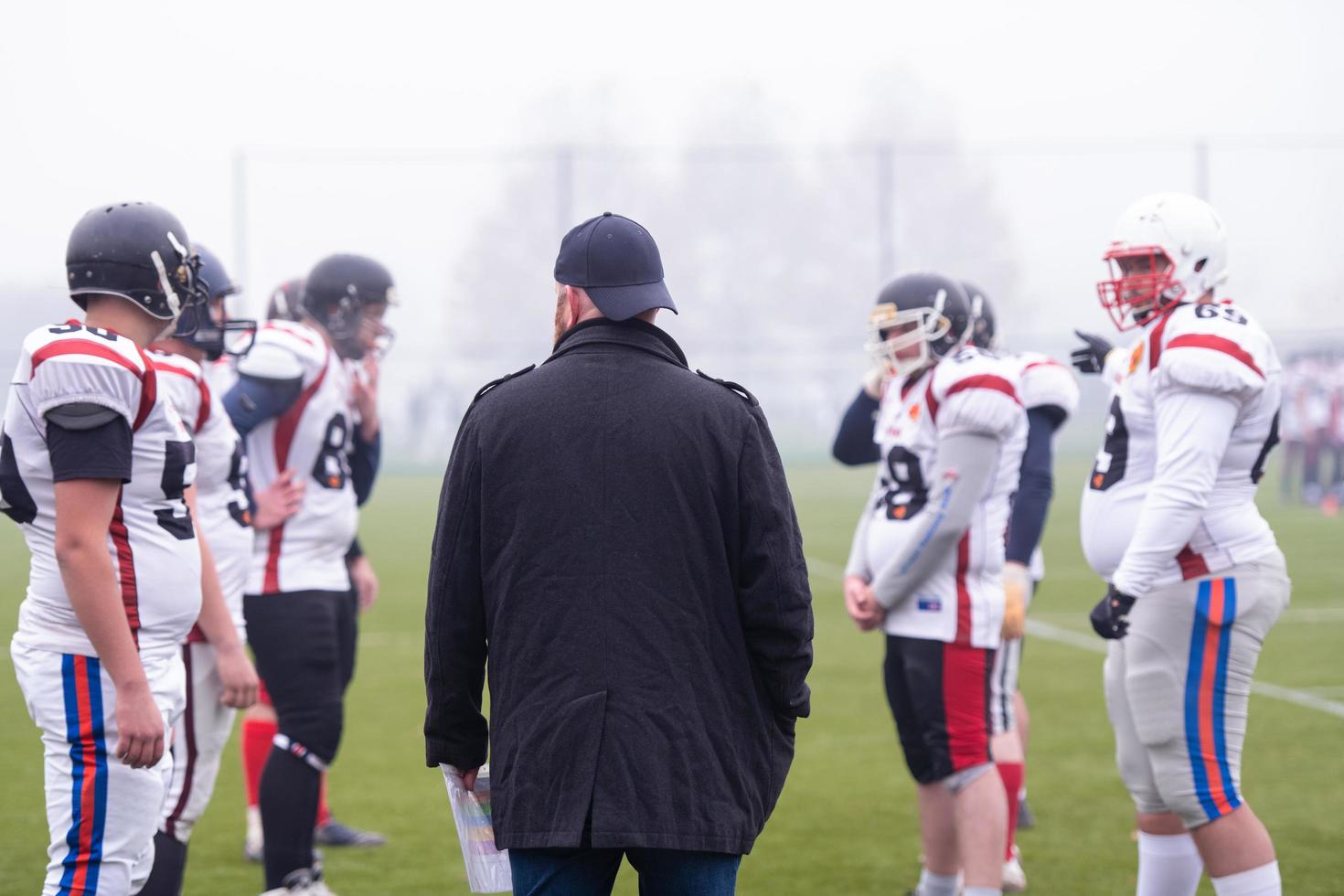 american football players discussing strategy with coach photo
