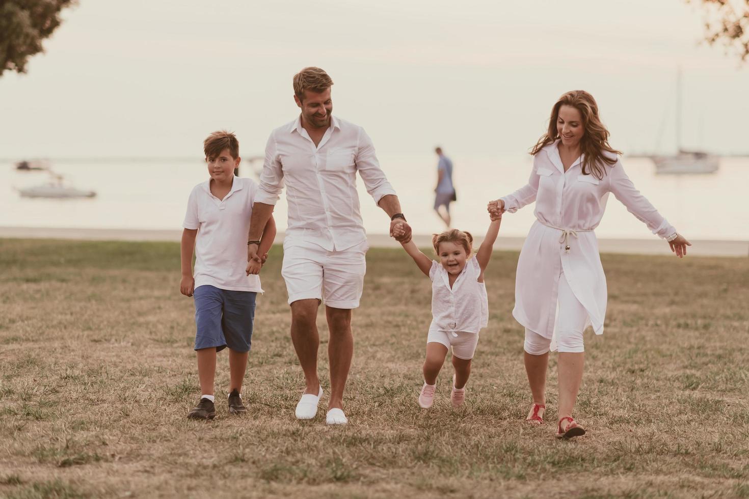 Senior couple in casual clothes with their children, boy and girl enjoy the beach spending a vacation together. Family time . Selective focus photo