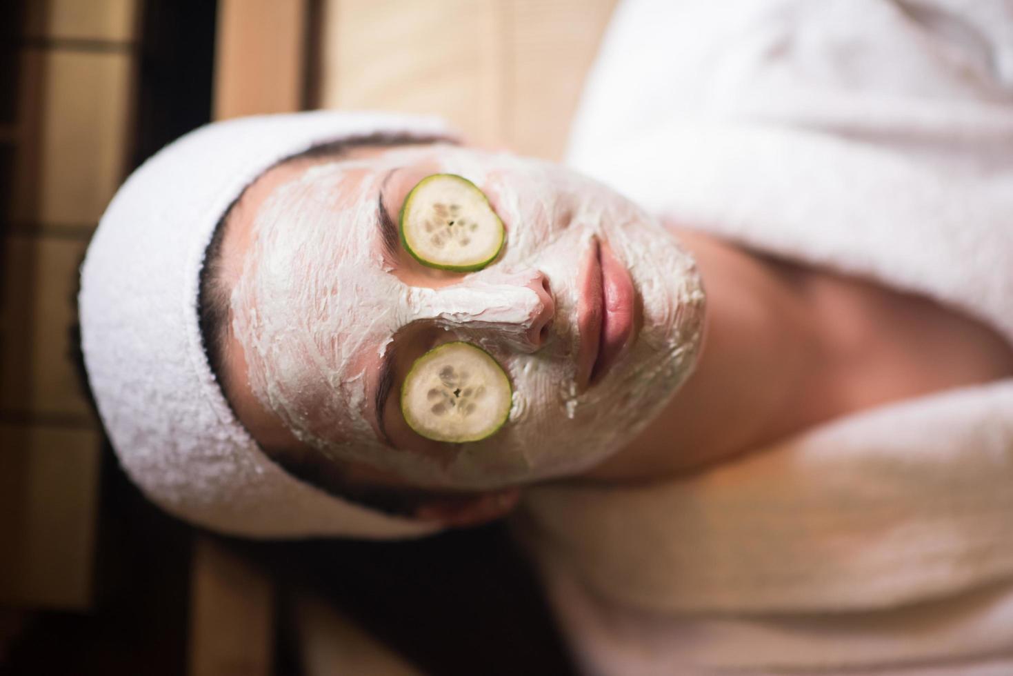 woman is getting facial clay mask at spa photo