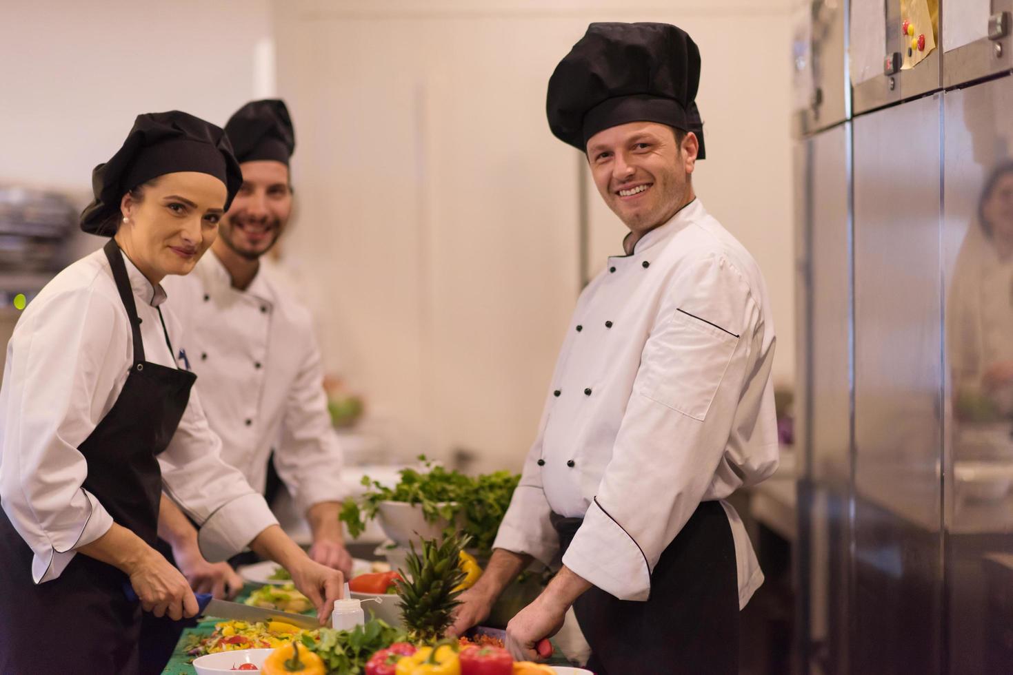 equipo de cocineros y chefs preparando comida foto