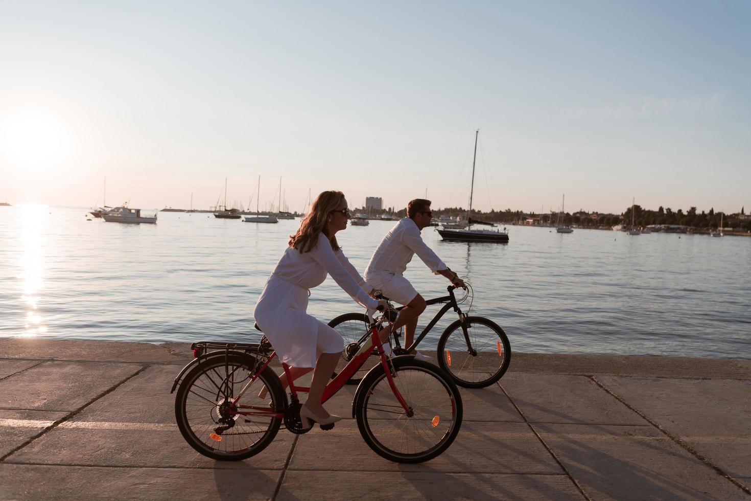 Senior couple enjoying a beautiful morning together riding a bike by the sea. Selective focus photo