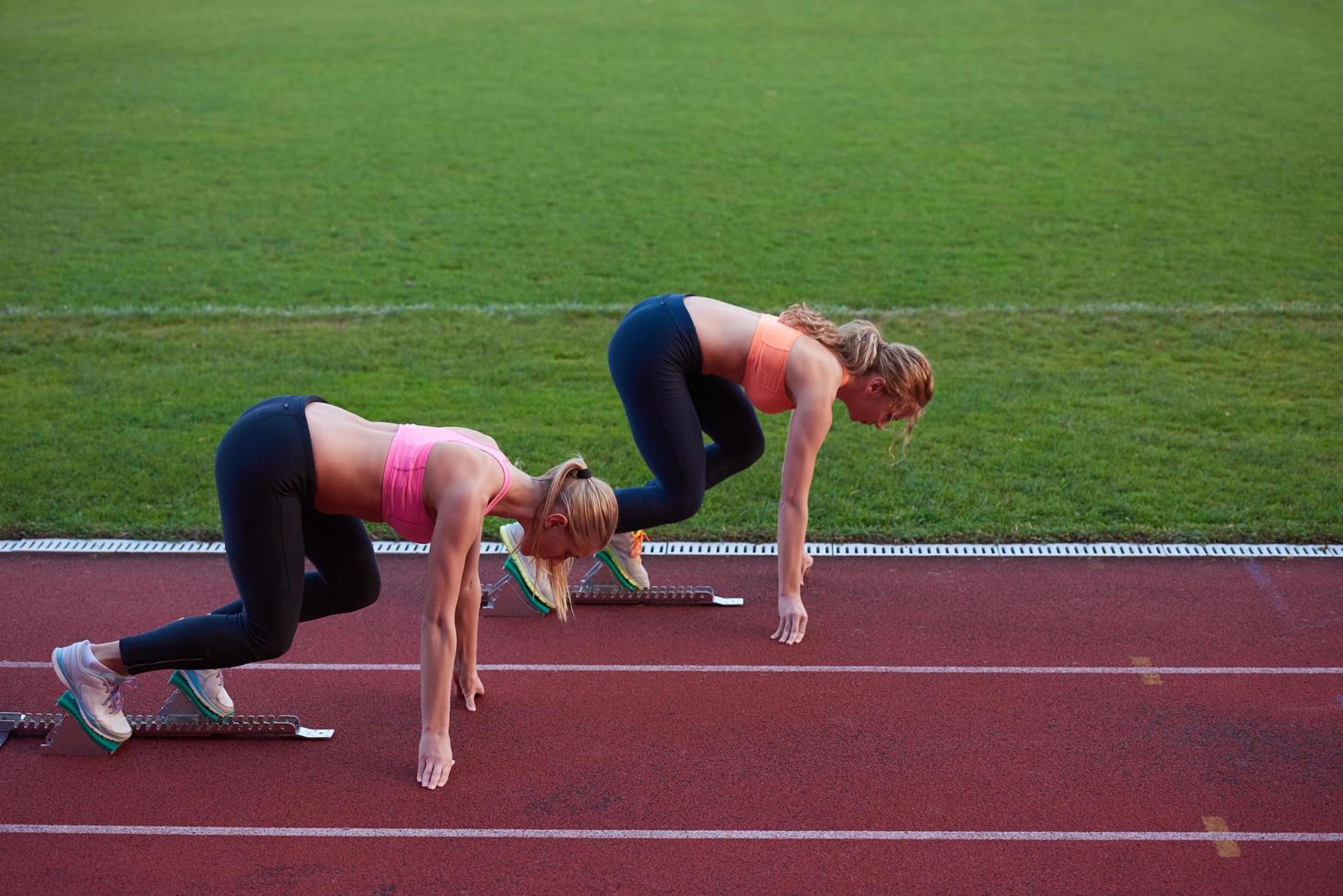 grupo de mujeres atletas corriendo en la pista de carreras de atletismo foto