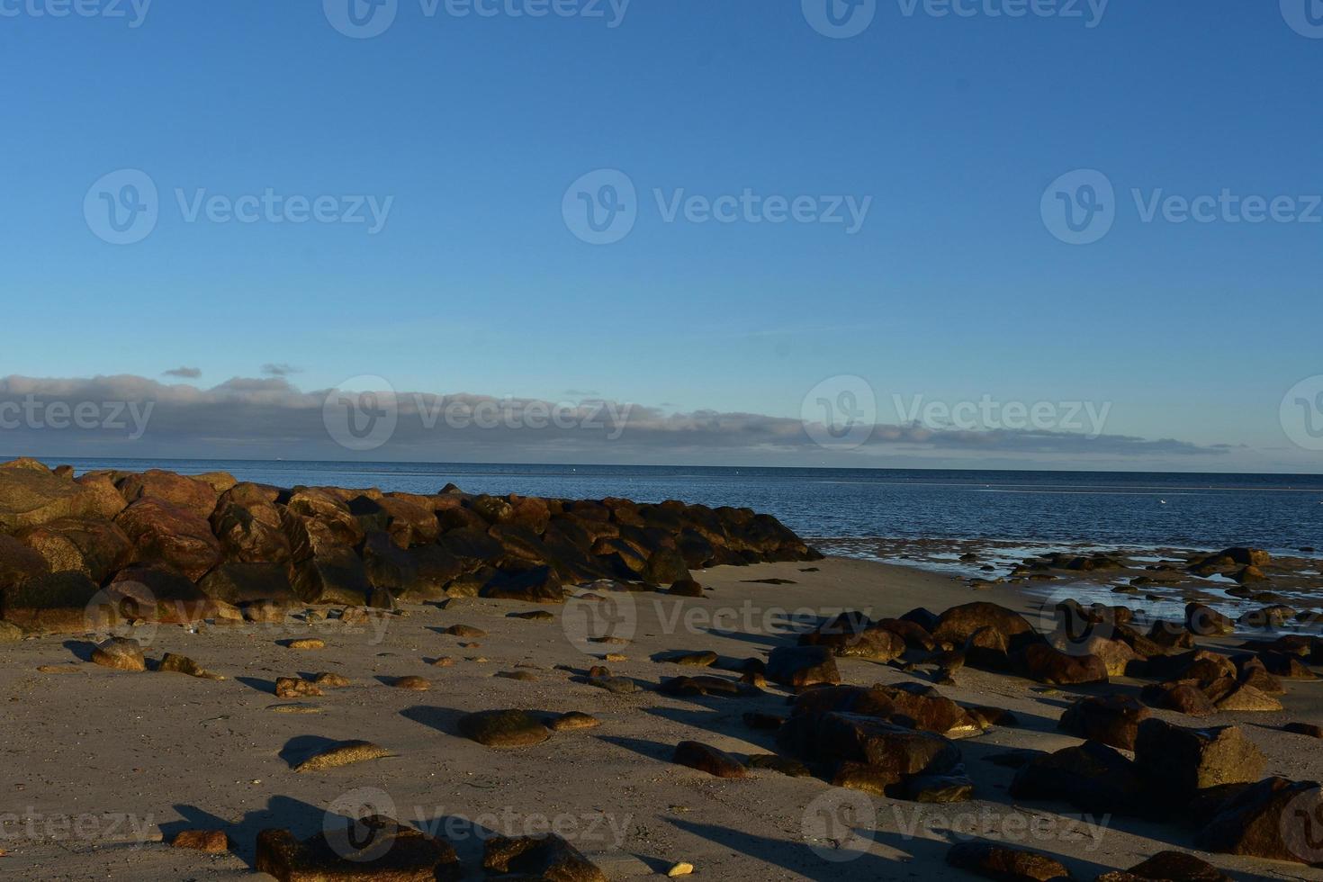 Bright sunny day with a large jetty on a beach photo