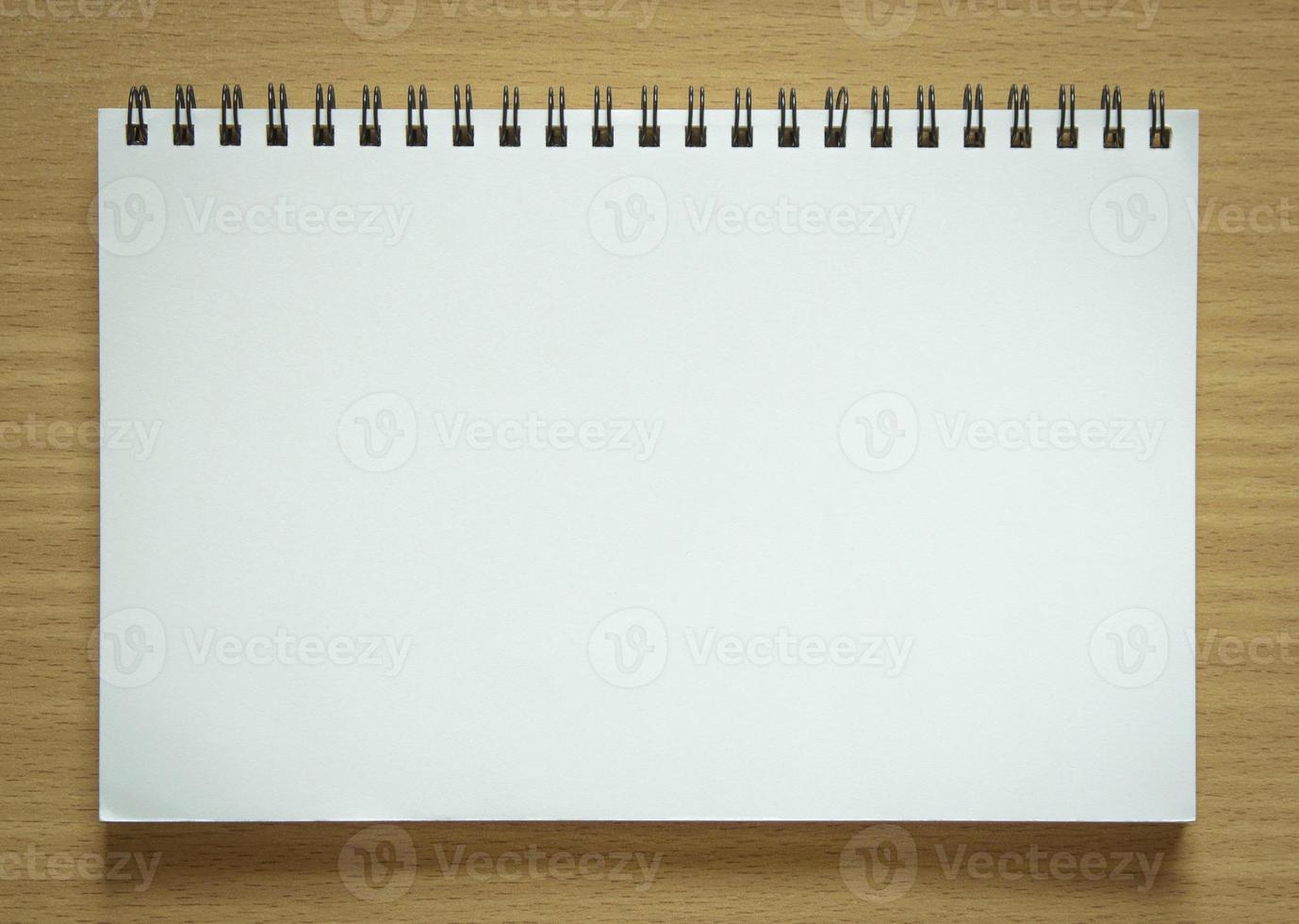 blank spiral notepad on wood background photo