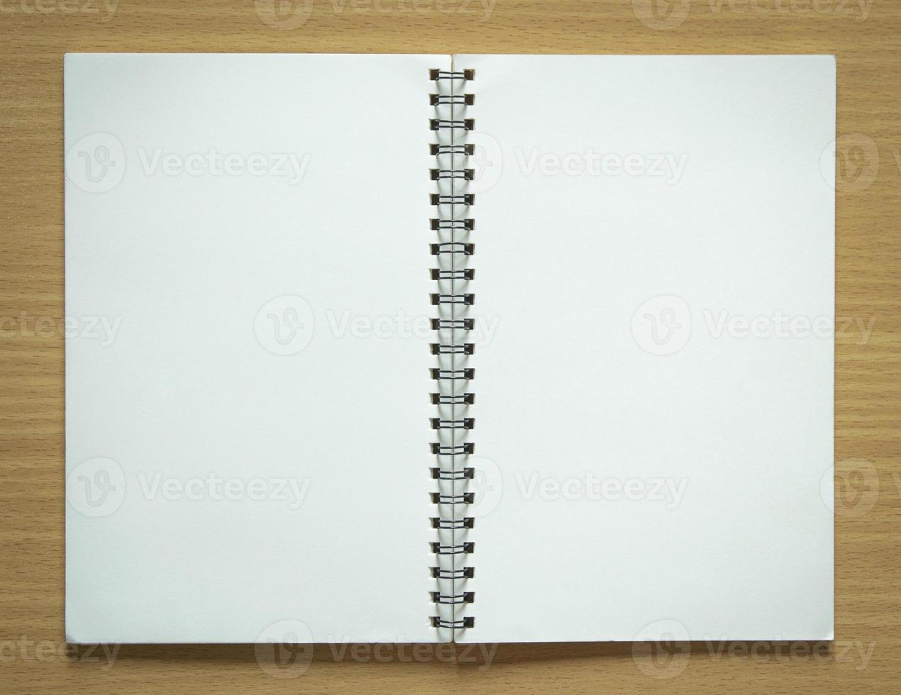 blank spiral notepad on wood background photo