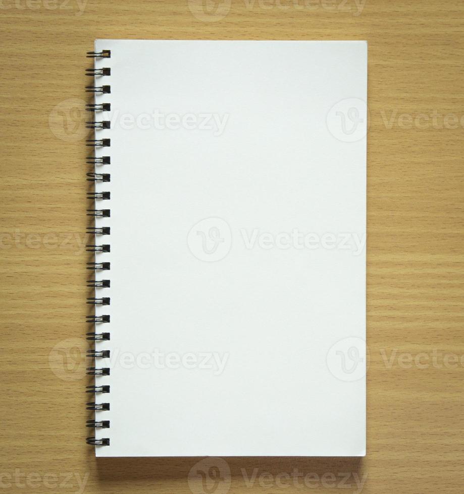blank spiral notebook on wood background photo
