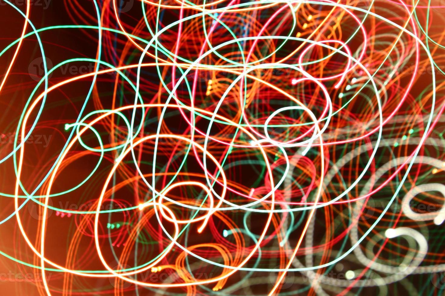 abstract color swirl garland lights. Blurred glowing on dark background photo