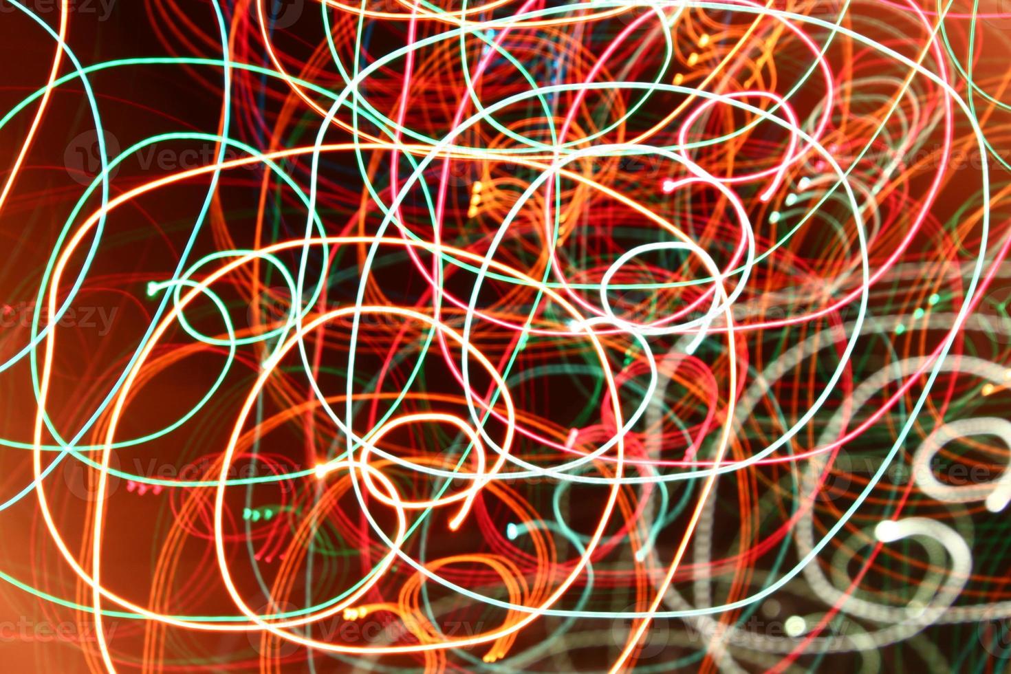 luces de guirnalda de remolino de color abstracto. resplandor borroso sobre fondo oscuro foto