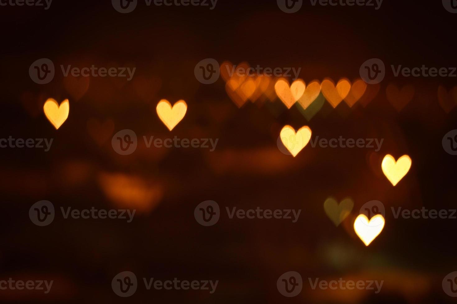 Heart shape bokeh lights on dark background. City lights defocused photo
