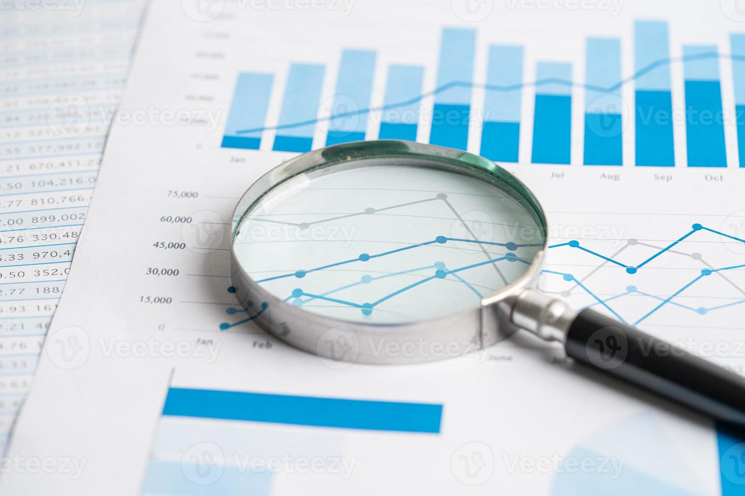 Magnifying glass on chart graph spreadsheet paper. Financial development, Banking Account, Statistics, economy, Stock exchange trading, Business office company meeting concept. photo