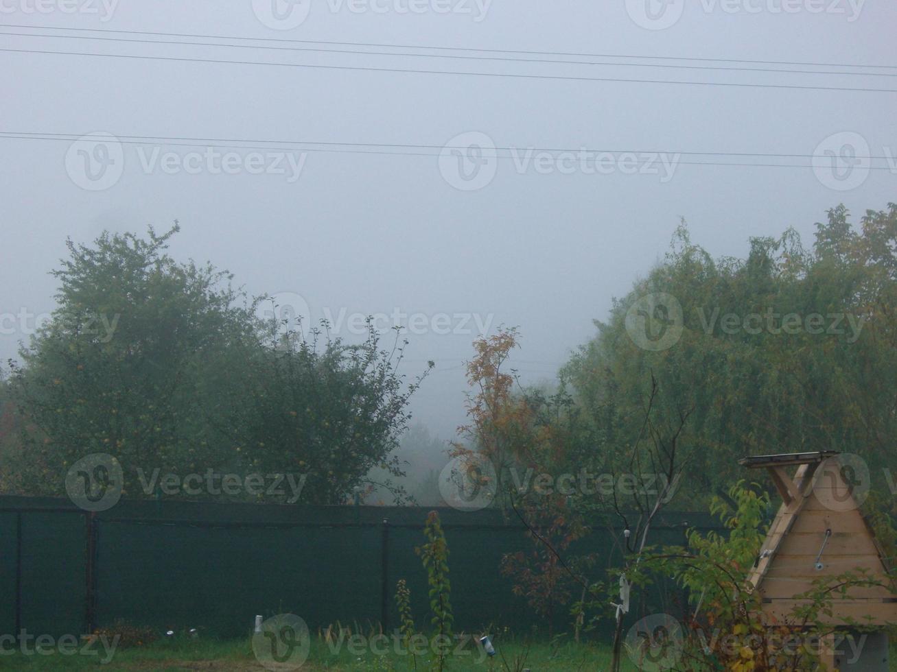 Autumn morning mist in the village photo